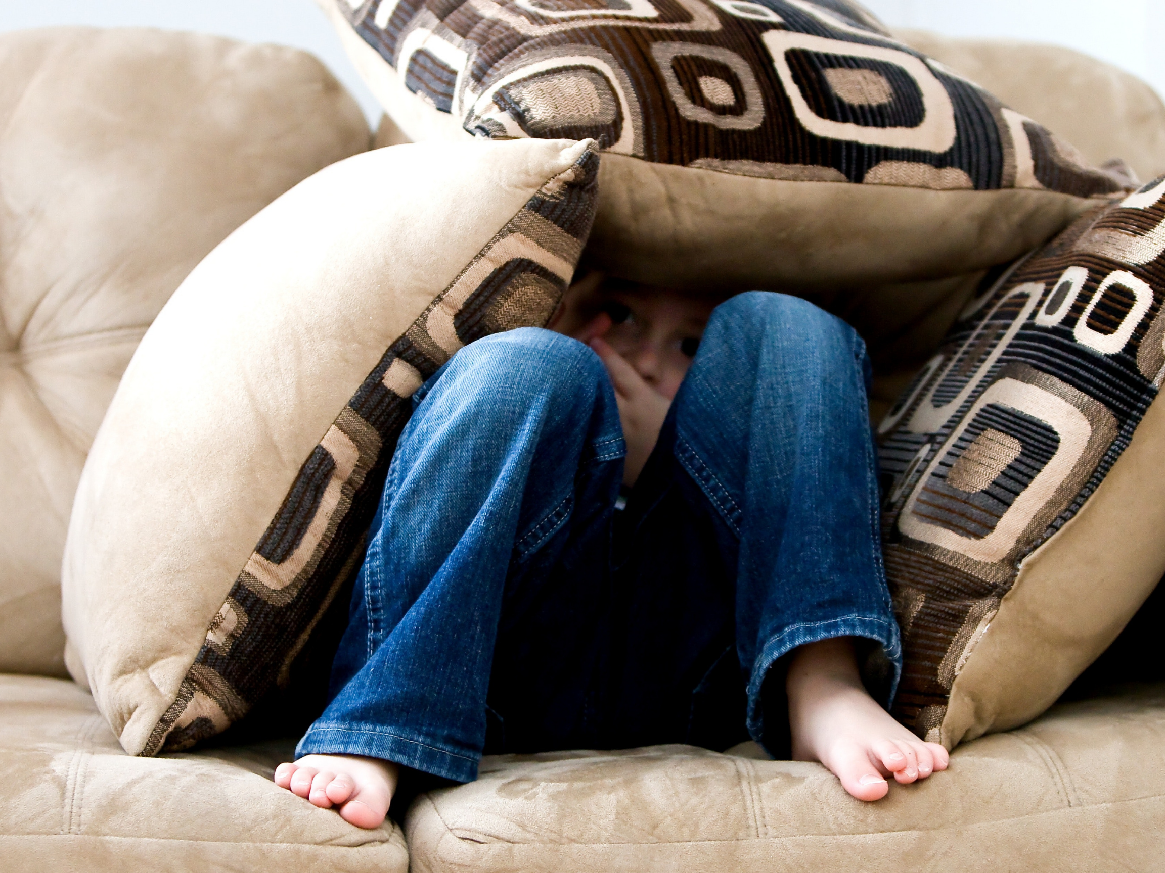 child covered in pillows on couch | charter school waiting list