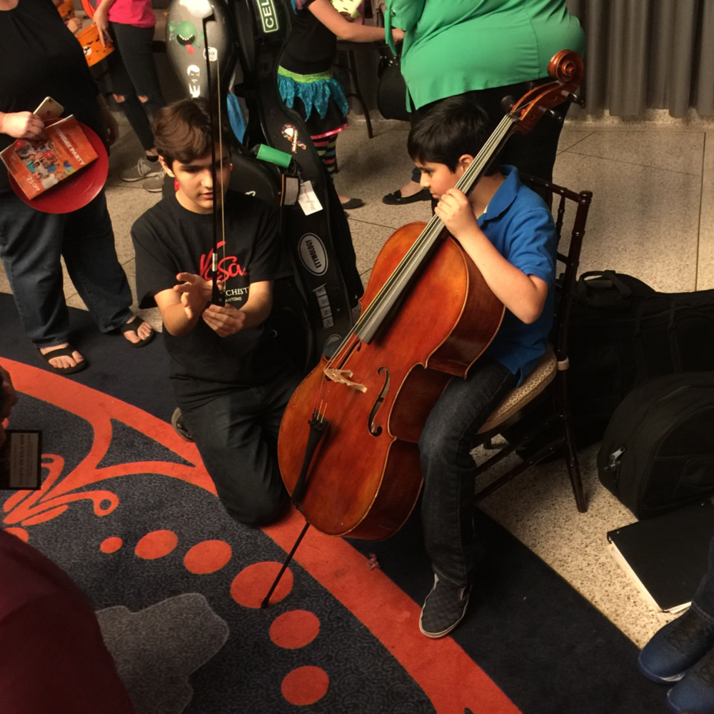 YOSA cellist at the instrument petting zoo at the San Antonio Symphony Halloween Spooktacular | San Antonio Charter Moms