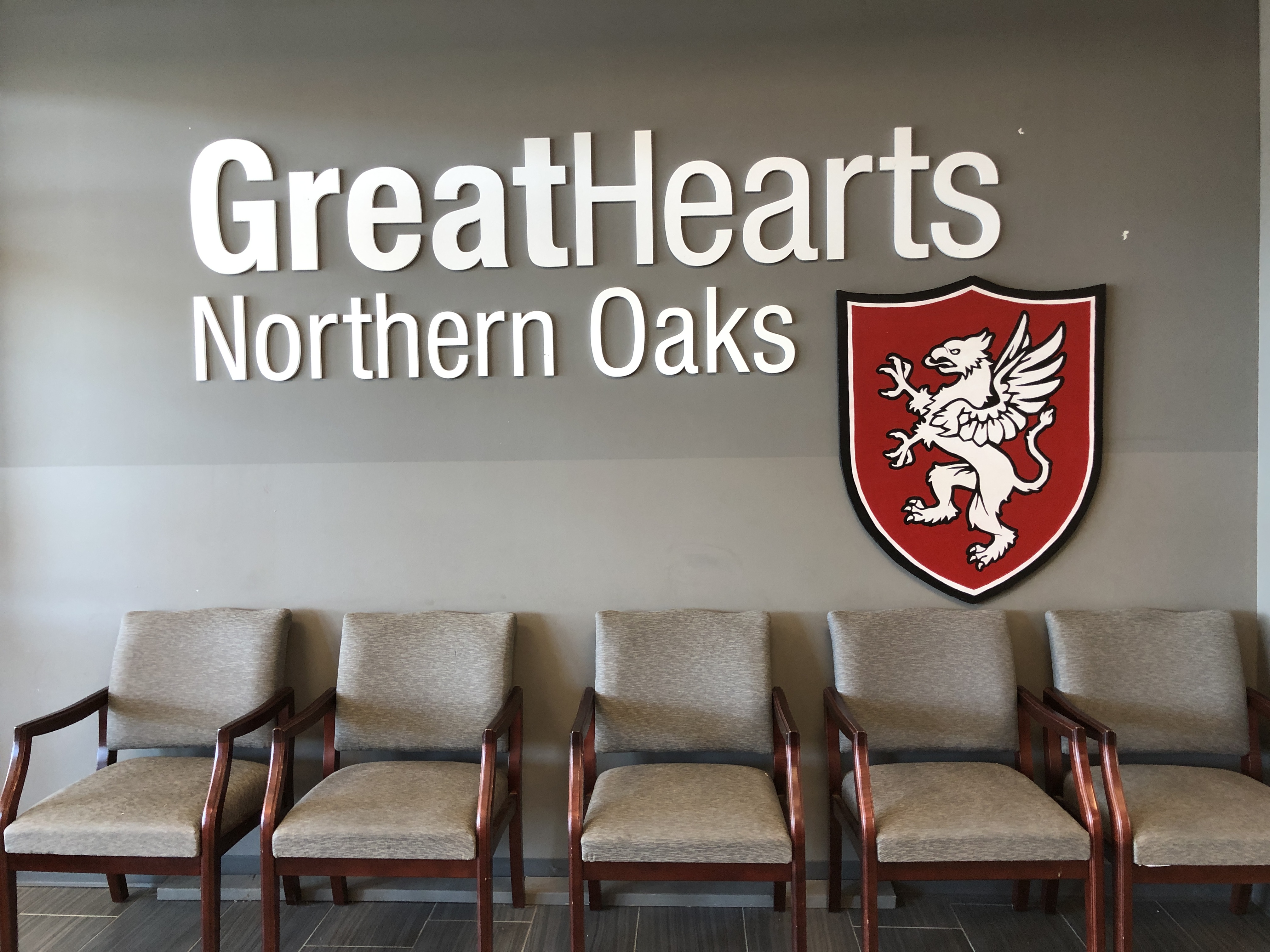 great hearts northern oaks logo on school wall above chairs