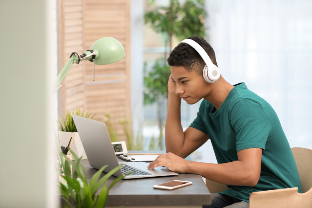 young man on laptop with headphones, article titled "What Special Education Parents Want to Keep from COVID-19"
