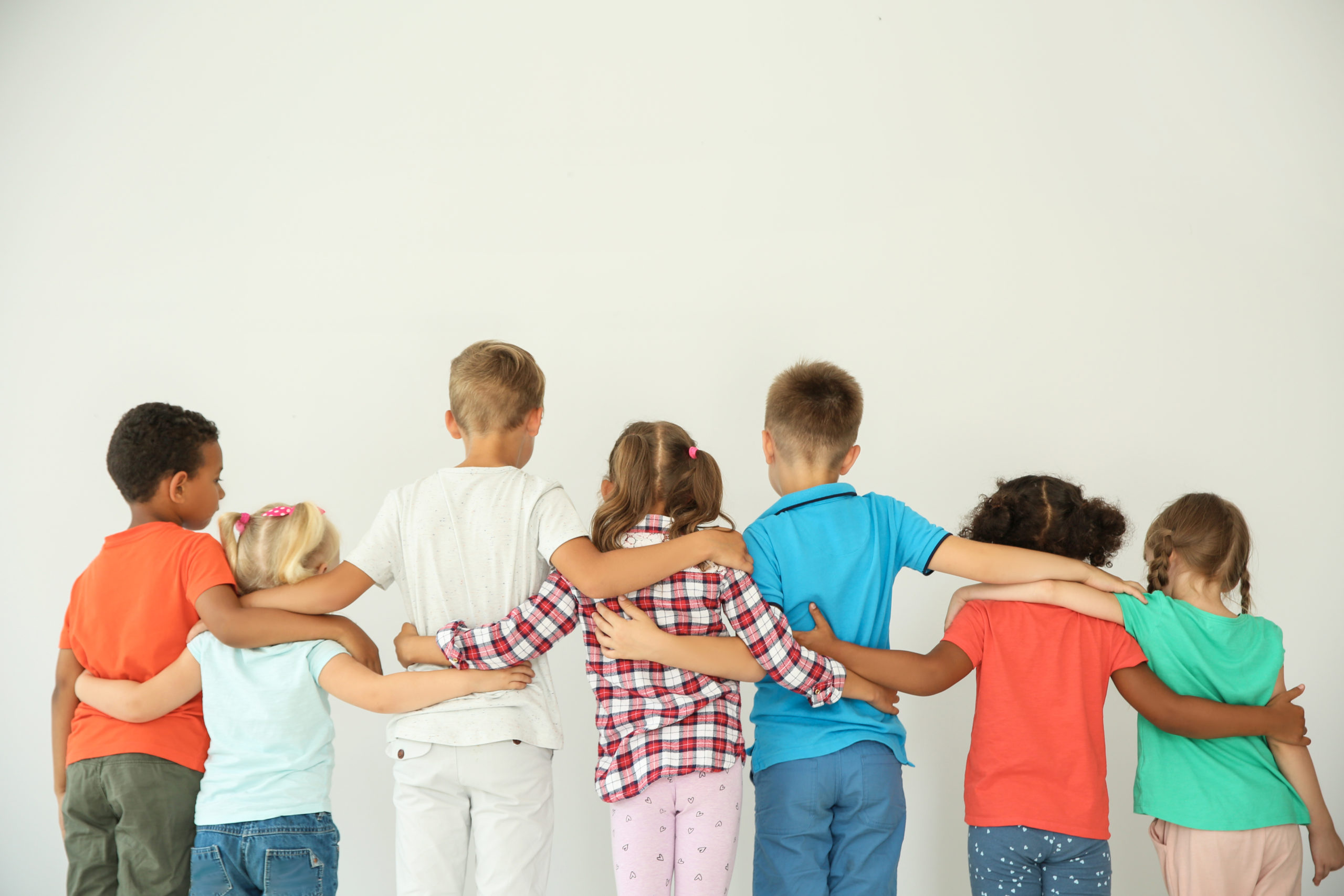 group of diverse kids facing away and wrapping arms around each other