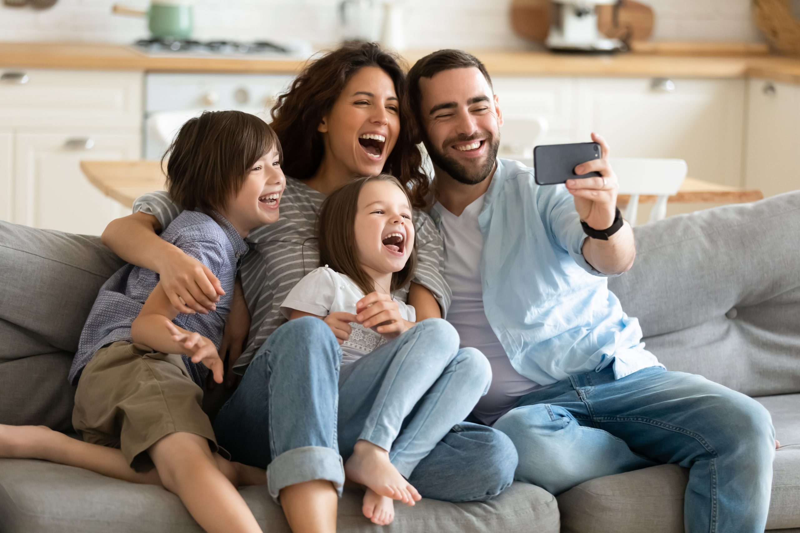 happy family taking selfie all together on couch