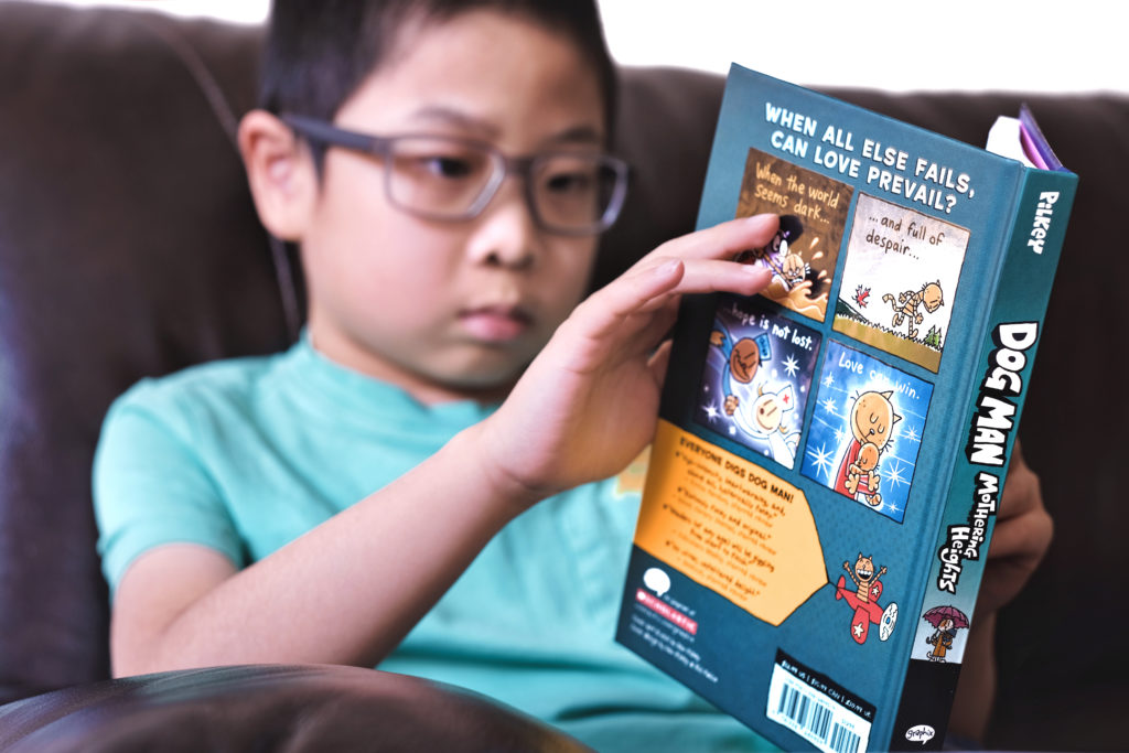 young boy reading graphic novel