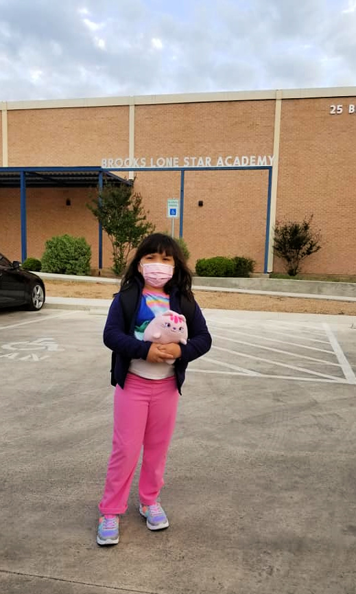 Karina Gomez wearing mask in front of Brooks Lone Star Academy