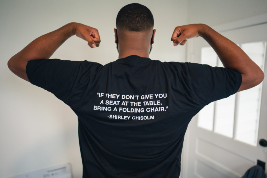 T-shirt with quote, "If they don't give you a seat at the table, bring a folding chair." Shirley Chisolm